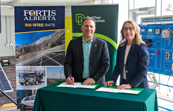 Stuart Callum & Janine Sullivan signing a MOU while smiling at camera