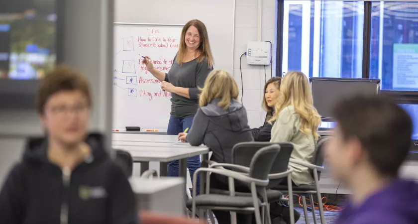 Mature students watching an instructor with students in the foreground..