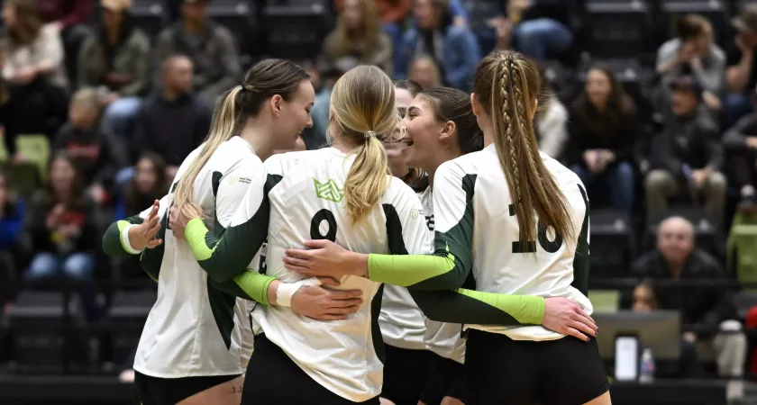 Queen's Volleyball student-athletes huddle during a game