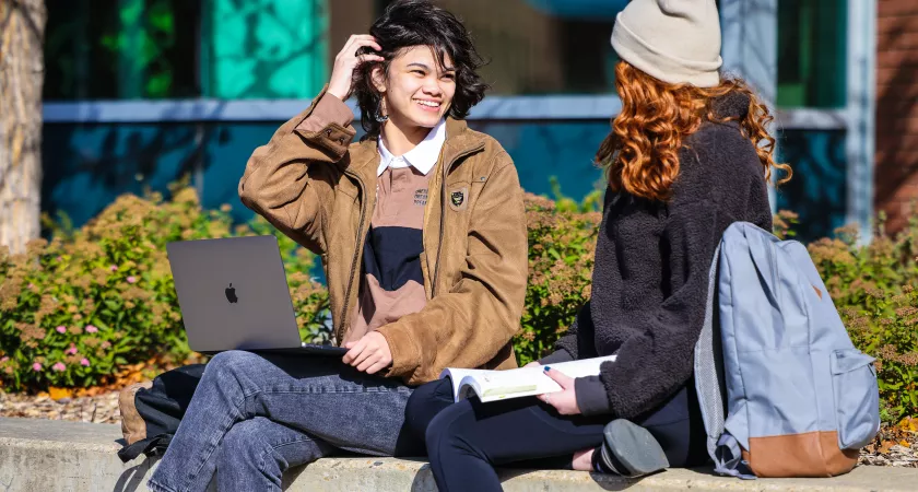 two students sitting outside