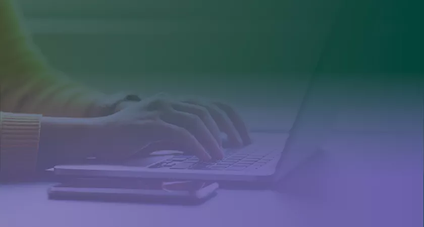 A close up of hands typing on a laptop with a green to purple gradient overtop
