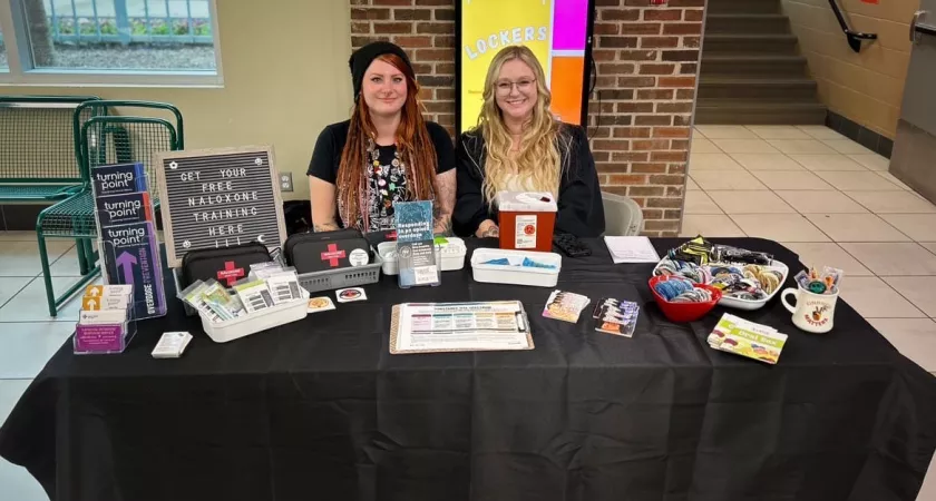 Two Turning Point employees at a table full of information tools.