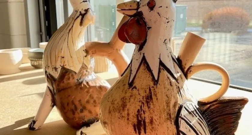 Two of Trudy Golley's ceramic creations. One looks like a rooster and one like a howling dog