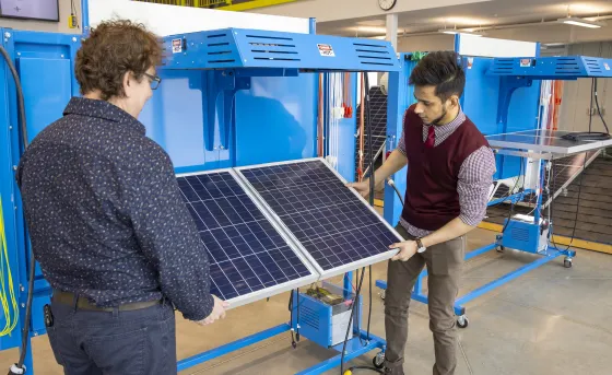 Instructor and student examining solar panel