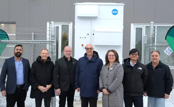 A group of representatives from RDP and Exro Technologies stands outside in front of the First Cell Driver Energy Storage System