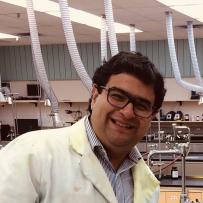 Smiling headshot of Ibrahim Matar Briman in a labcoat