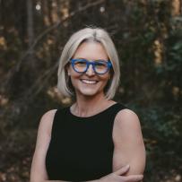 Smiling headshot of Laura K. Davis against a lush forest