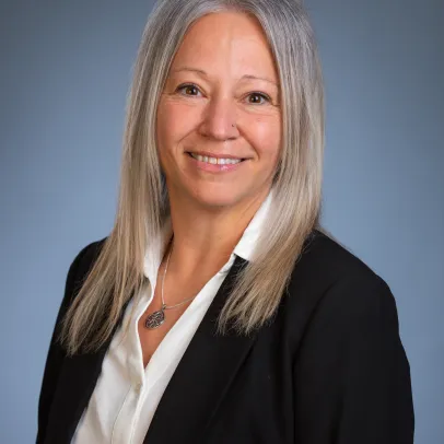 Smiling headshot of Cristal Glass-Painchaud posing in front of a grey background
