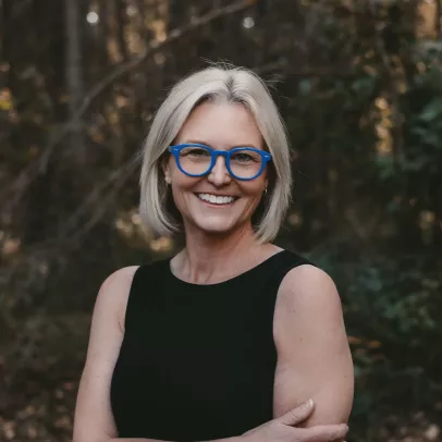 Smiling headshot of Laura K. Davis against a lush forest