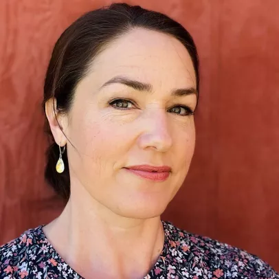 Shauna Garrow headshot on a orangey-red background