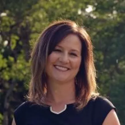 Smiling headshot of Dr. Kathryn Pallister against a background of soft trees