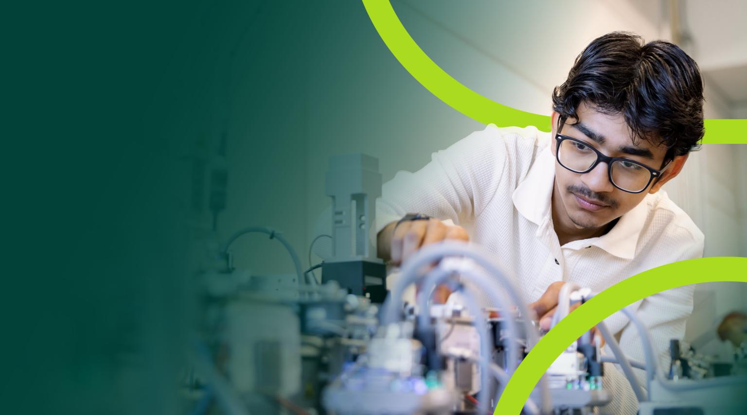 A male student leans over some lab equipment. Green graphical elements intertwine with the photo