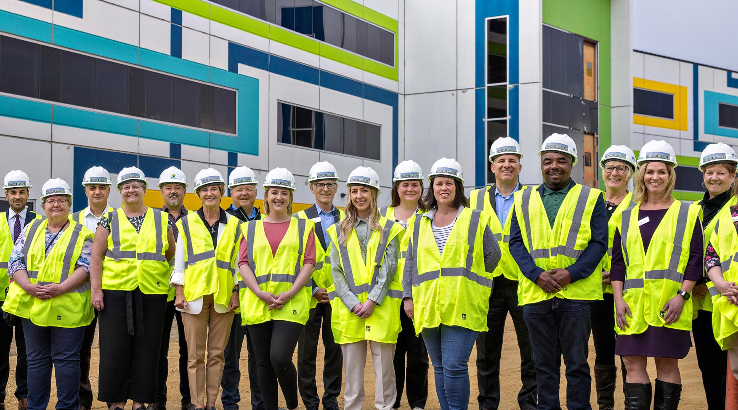 Board of Governors Members stand in front of the Sheldon Kennedy Centre of Excellence while under construction on main campus