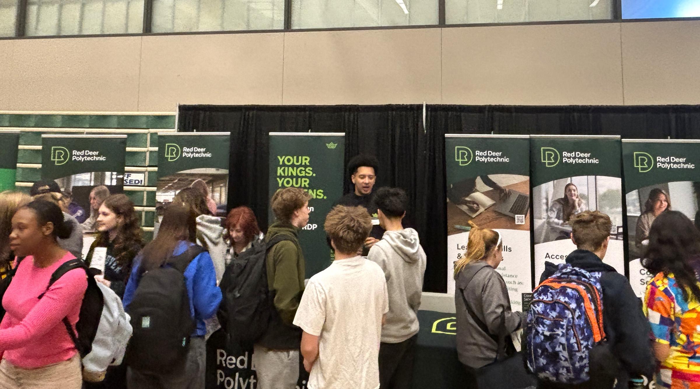 Group of students lines up in front of a both showcasing Red Deer Polytechnic programs