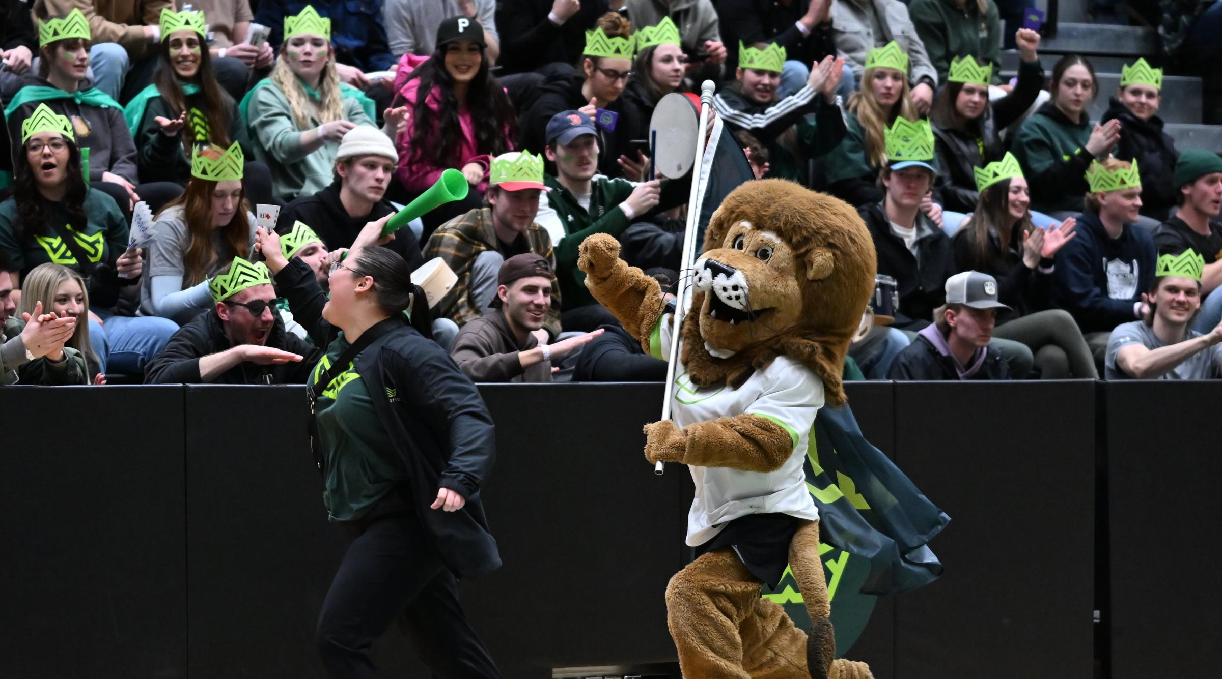 Rufus, RDP's lion mascot, runs in front of a cheering crowd waving an RDP flag