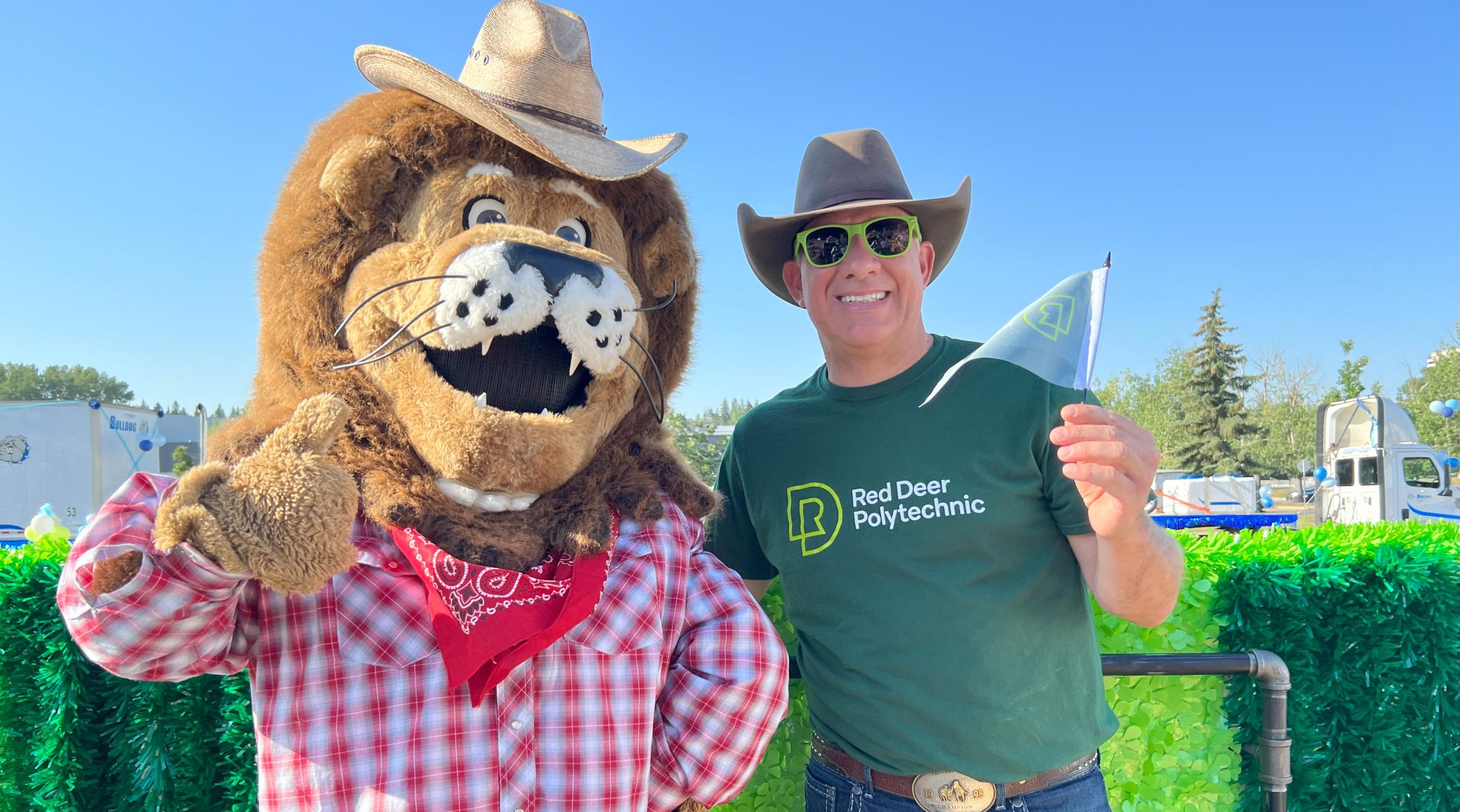 RDP's lion mascot, Rufus, dressed in a cowboy hat and flannel stands next to RDP's President, Stuart Cullum