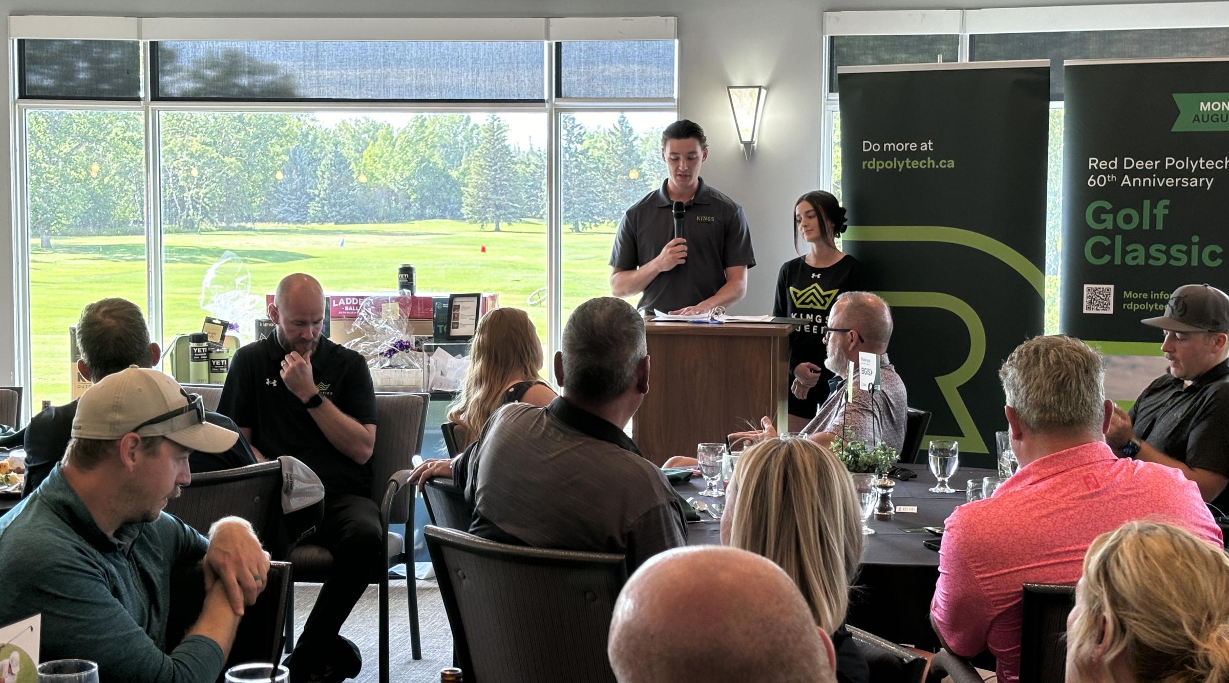 Student athletes speak in front of a seated crowd at the 60th anniversary Golf Classic Awards dinner