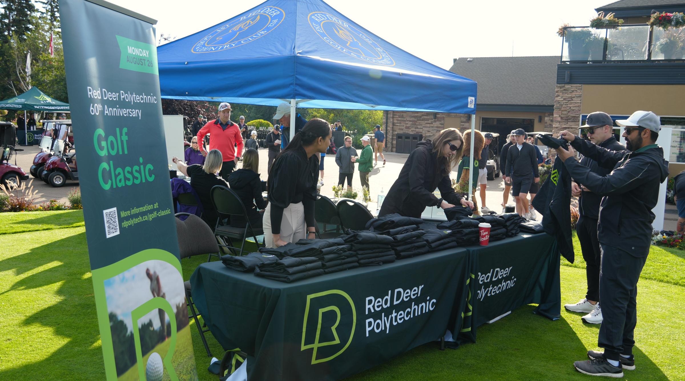 RDP Staff work the Golf Classic registration table and hand out RDP Athletics jackets to golfers