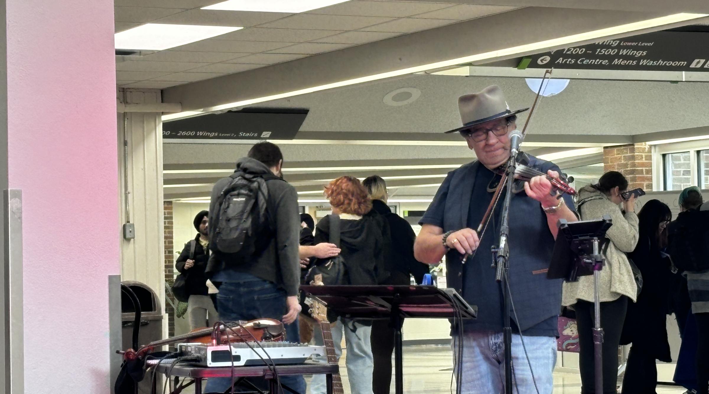 A Metis man playing the fiddle in the Bottling Forum at RDP