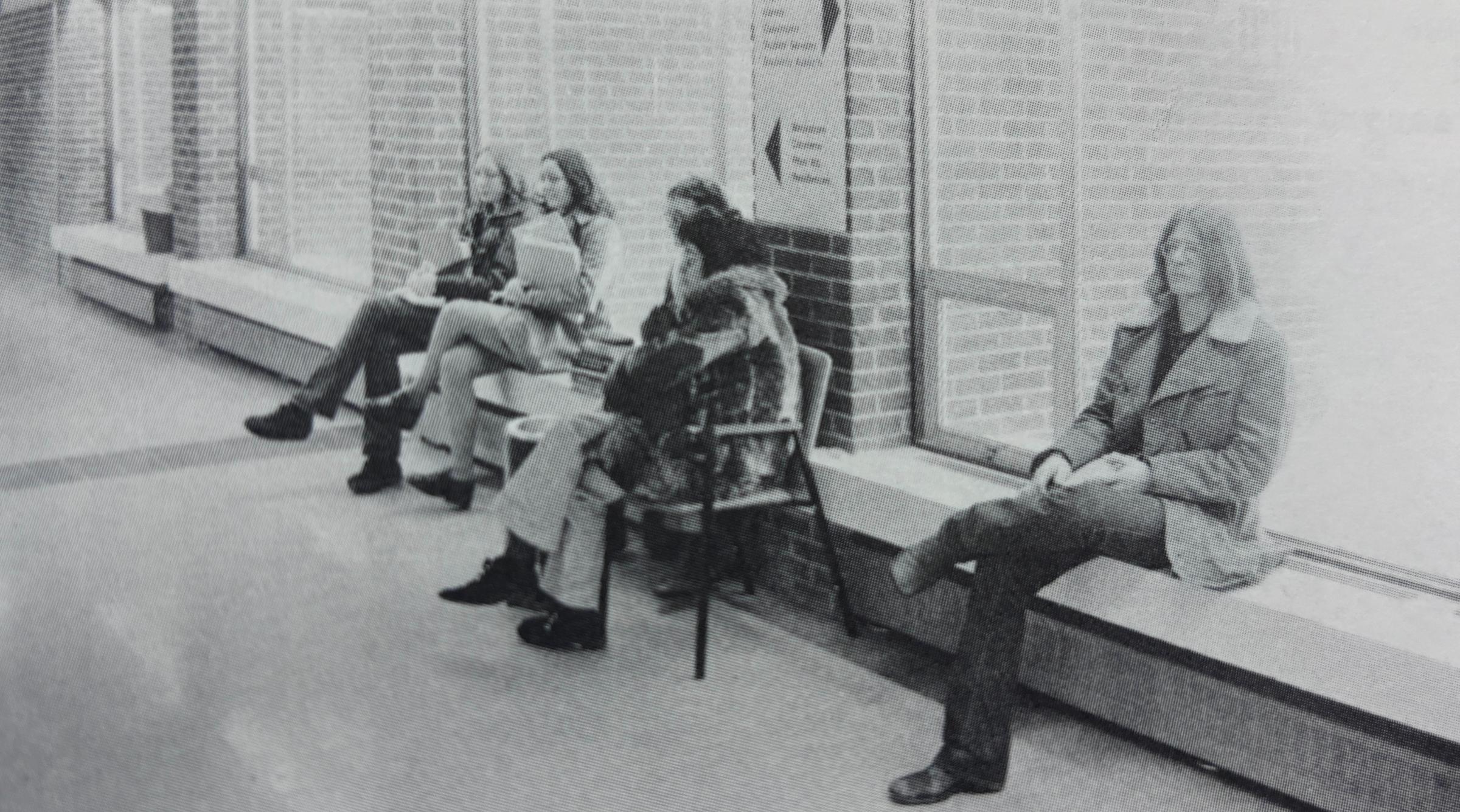 An archival photo of students sitting against a wall in RDP's main hallway