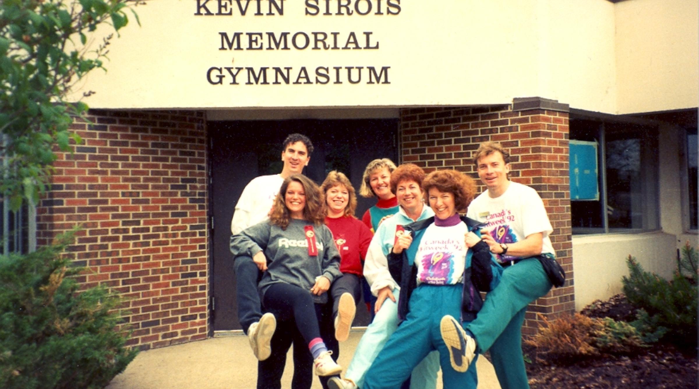 An archival photo of a group of happy students outside the Kevin Sirois Memorial Gymnasium
