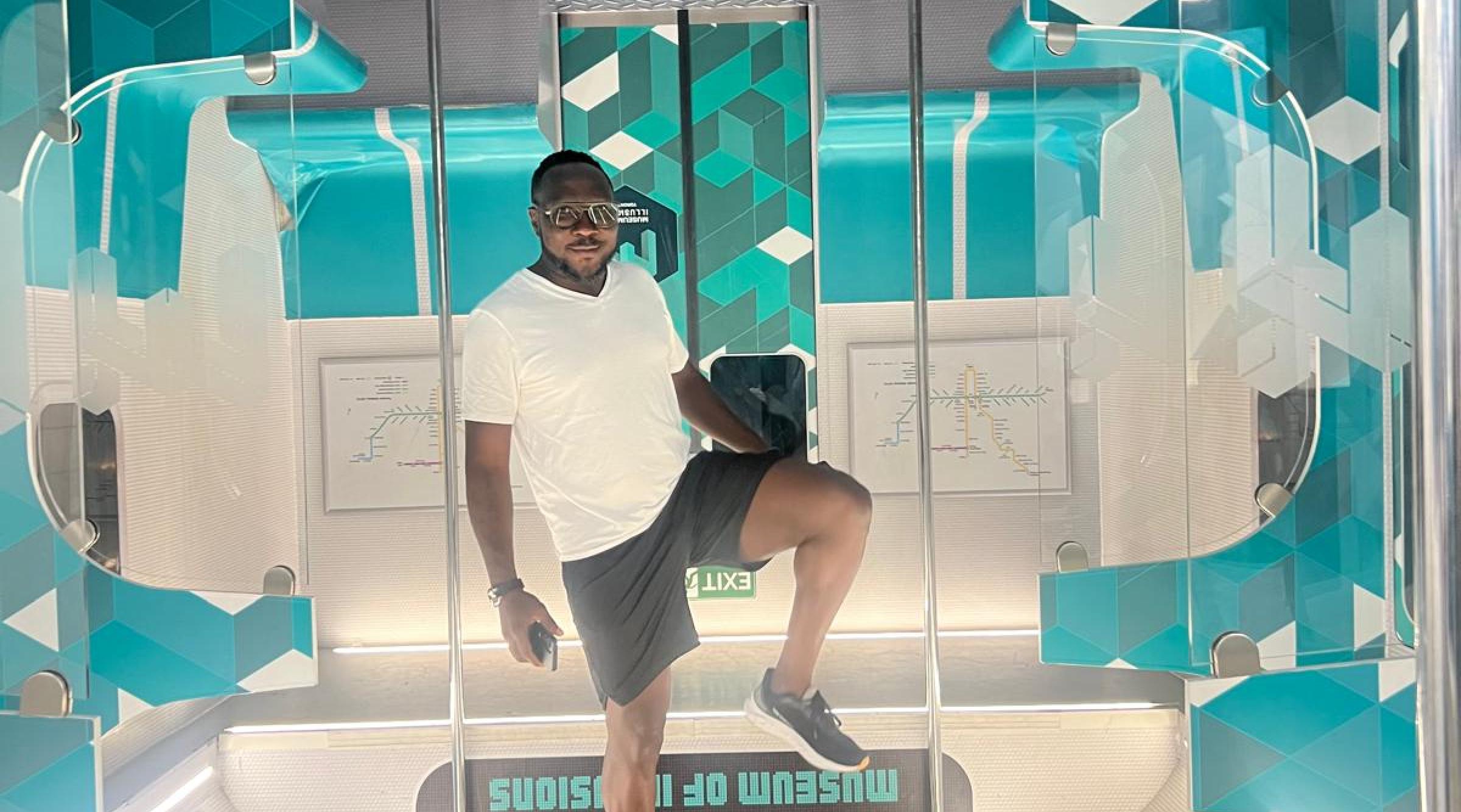 Emile Johnson stands in some futuristic exhibit reminiscing of a subway train, but upside down