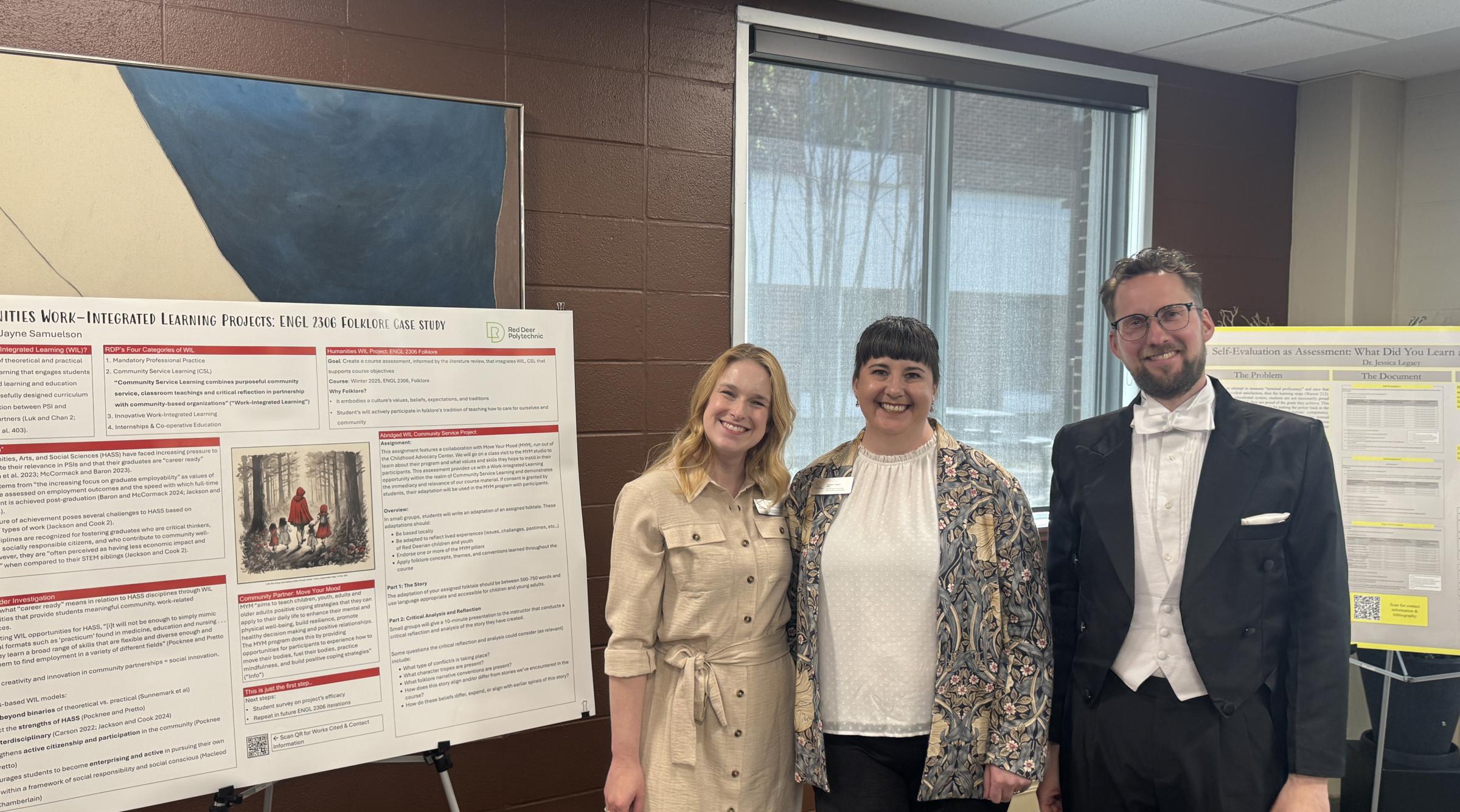 Three faculty members stand smiling besides posterboards that explain their research at the RoSA Awards