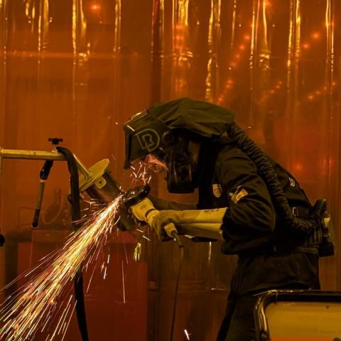 Ben Rainforth in full welding gear at WorldSkills works on some metal as sparks fly