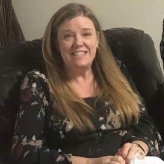 Judy, with long blonde hair, sits in a large chair.