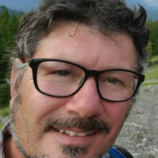 Trent with short brown hair and black glasses.