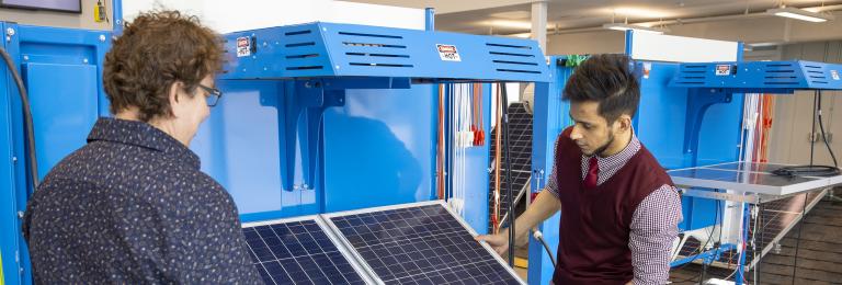 Instructor and student examining solar panel