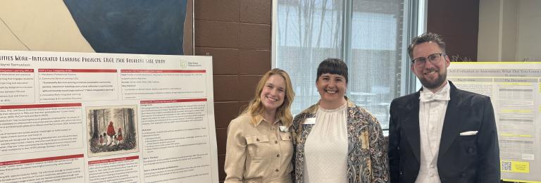 Three faculty members stand smiling besides posterboards that explain their research at the RoSA Awards