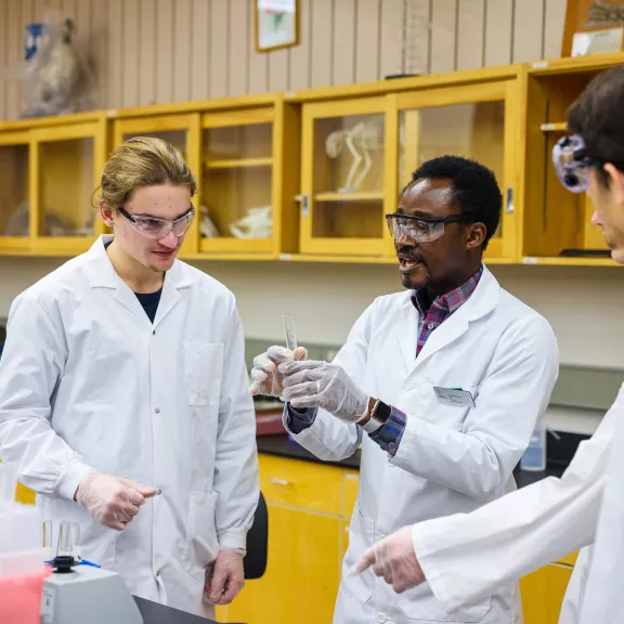 University Science instructor in lab with two students