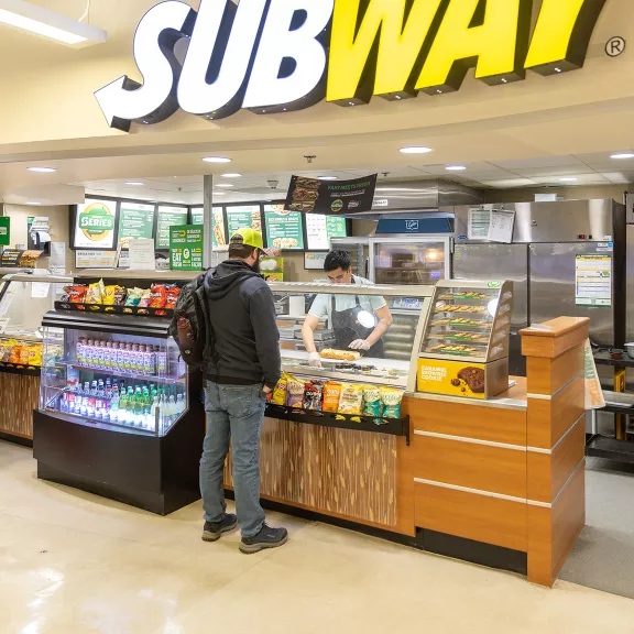 A person orders food from Subway, located in The Marketplace on main campus