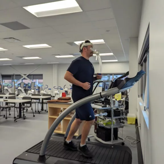 Man running on treadmill with a ventilator on his face