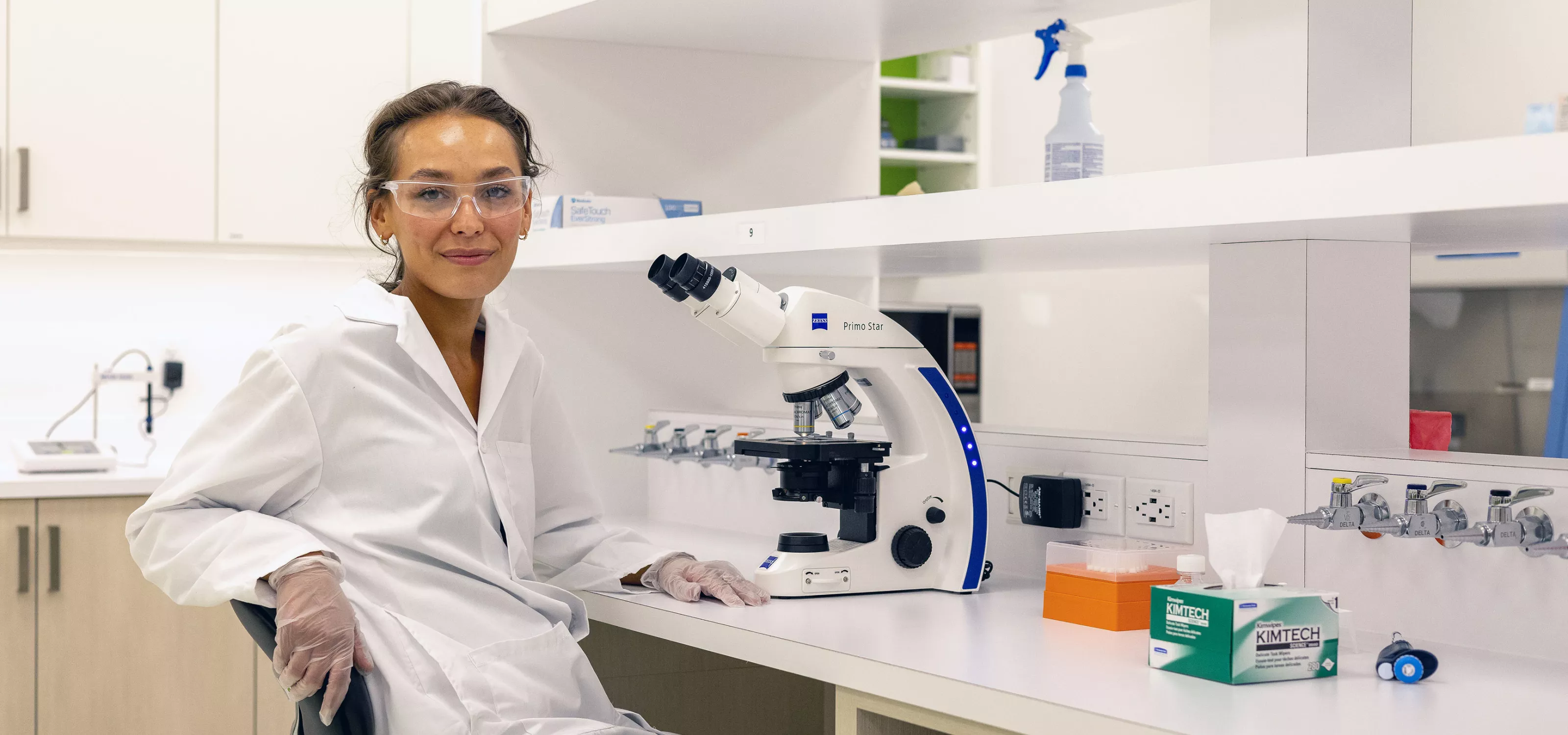 Indigenous Female smiling sitting by microscope