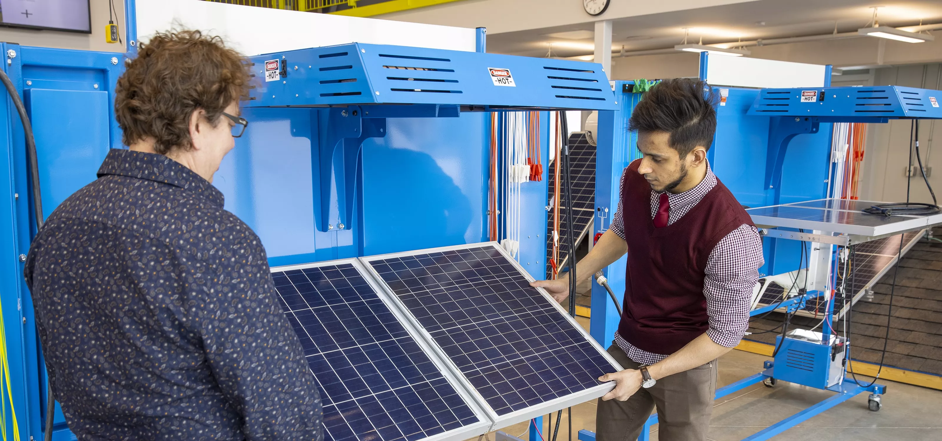 Instructor and student examining solar panel