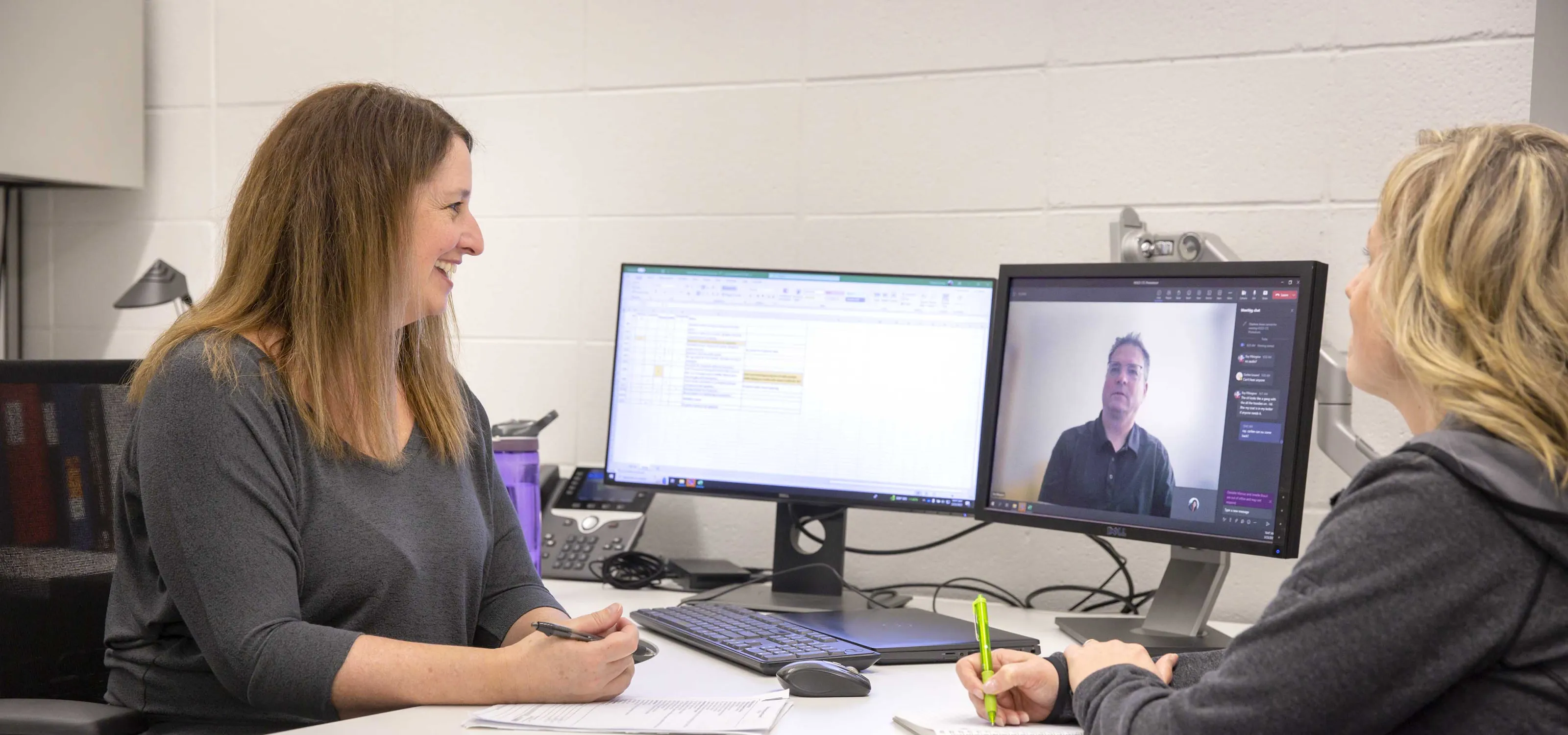 Two employees meeting with a client virtually.