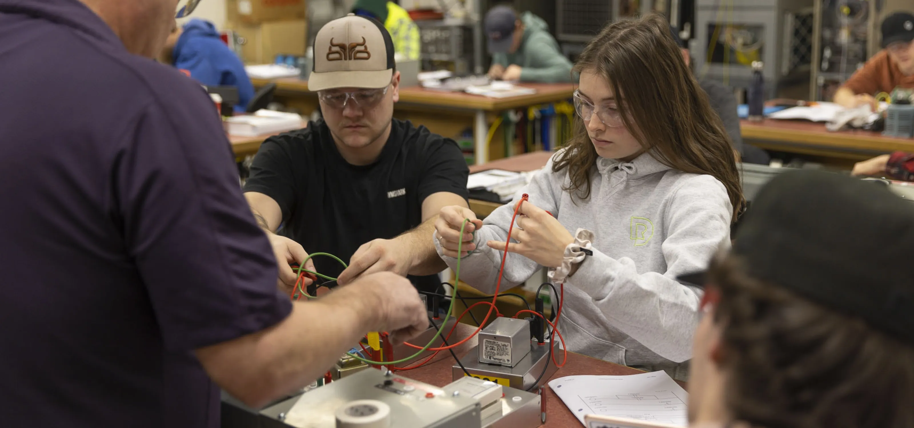 Two students work with wires in a lab.